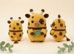 Three crocheted giraffe plush toys in different sizes, arranged on a light beige background with decorative green leaves in the corners. The center giraffe holds a green leaf, and all have brown spots and horns.