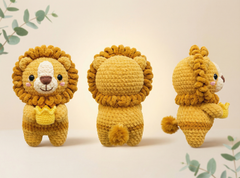 Three views of a crocheted lion plush toy in golden yellow and brown, shown from the front, back, and side against a warm beige background with subtle green leaf accents.