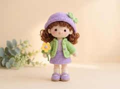 Crochet doll Sofi Petal in a lilac bucket hat and green jacket, holding a yellow crochet flower.